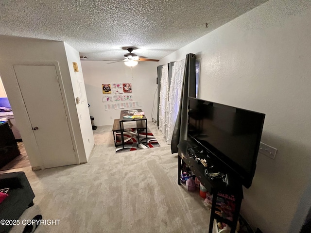 recreation room with a textured ceiling and ceiling fan