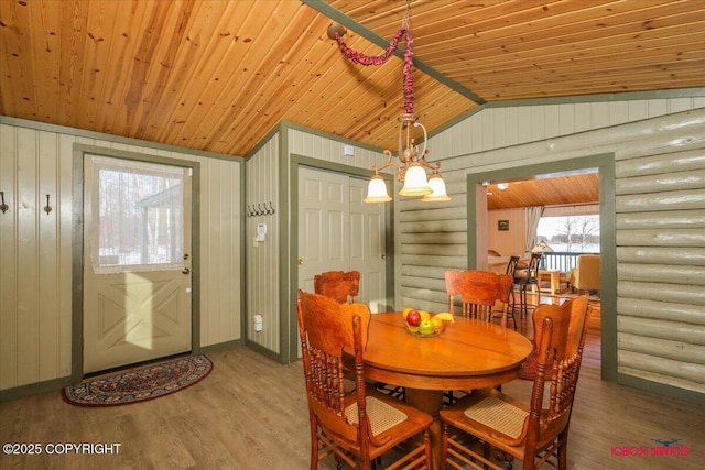 dining area featuring lofted ceiling, wood finished floors, and wooden ceiling