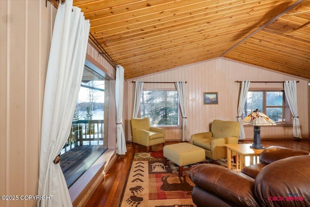 sitting room with lofted ceiling, wooden walls, wood finished floors, and wooden ceiling