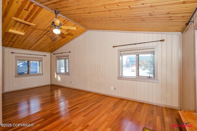 spare room featuring lofted ceiling, wood finished floors, baseboards, and wooden ceiling