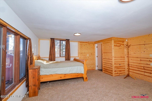 carpeted bedroom with wooden walls and multiple windows