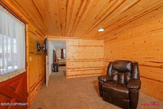 living area featuring wooden walls, wooden ceiling, and carpet