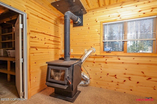 room details with wood walls, wooden ceiling, a wood stove, and carpet