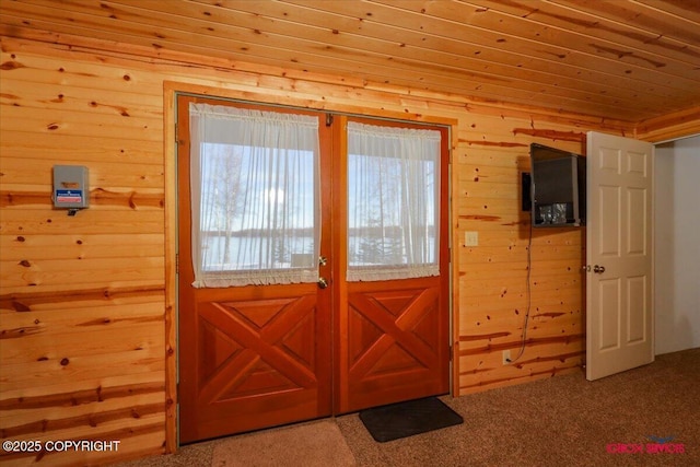 entryway with wood walls and carpet floors