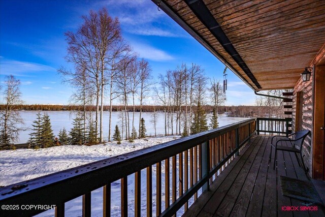 snow covered deck featuring a water view