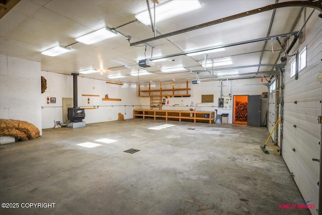 garage with a garage door opener and a wood stove