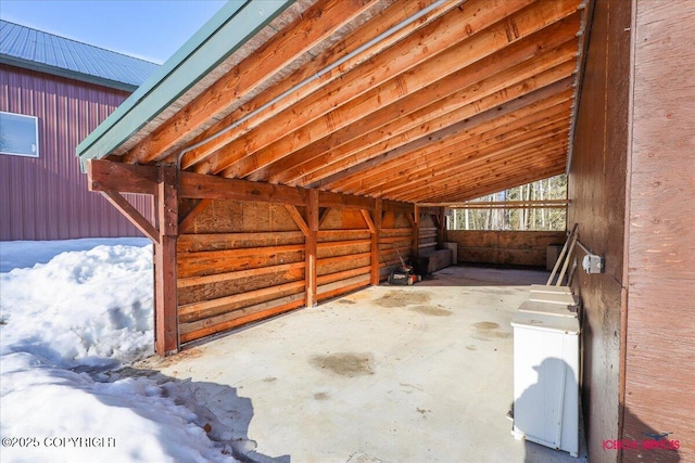 exterior space with unfinished concrete floors and vaulted ceiling