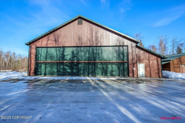 snow covered garage with a detached garage