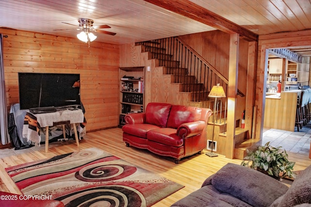 living area featuring stairway, wooden walls, wood ceiling, and wood finished floors