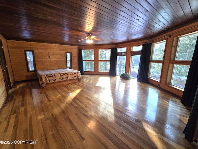 unfurnished bedroom featuring hardwood / wood-style floors, wooden walls, and wood ceiling