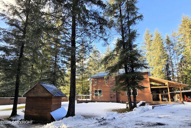 snow covered property featuring an outdoor structure