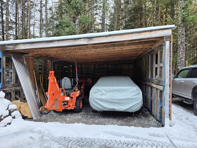 snow covered parking area with a carport and a pole building