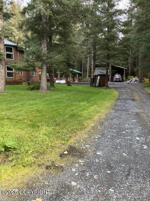 view of yard with gravel driveway and a carport