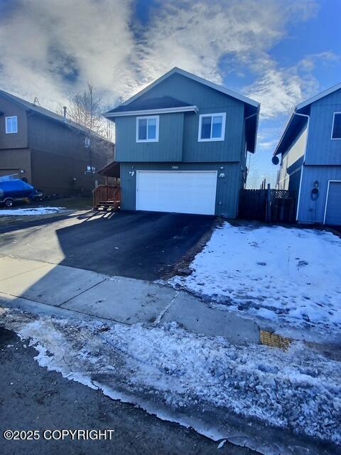 view of front of home with aphalt driveway and a garage