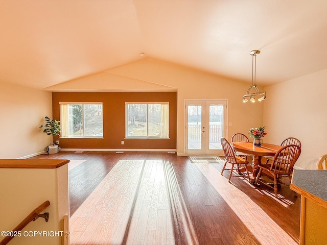 dining room with a wealth of natural light, lofted ceiling, and dark wood-style flooring