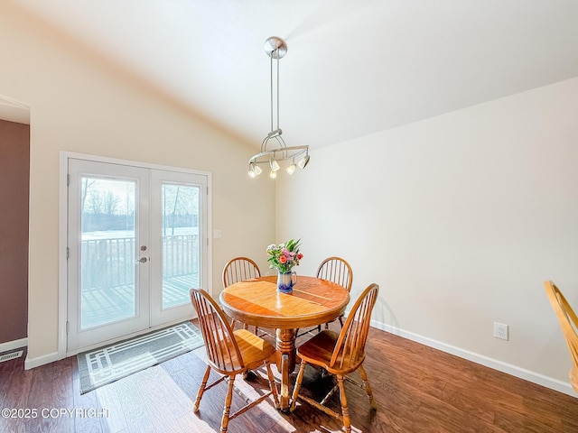 dining room with vaulted ceiling, wood finished floors, baseboards, and french doors