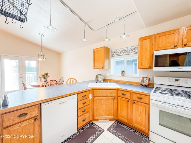 kitchen with a sink, decorative light fixtures, white appliances, light tile patterned floors, and vaulted ceiling