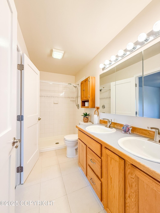 bathroom with a sink, toilet, tile patterned flooring, and a tile shower