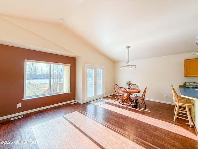 dining room with french doors, baseboards, hardwood / wood-style floors, and vaulted ceiling