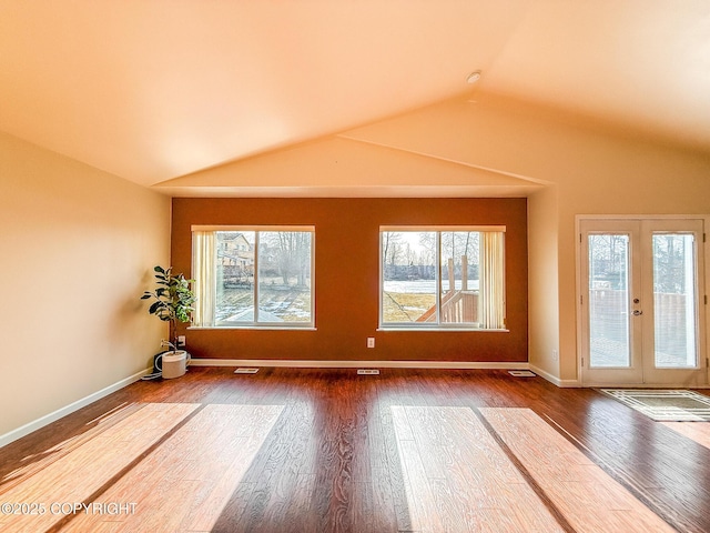 unfurnished room featuring visible vents, wood finished floors, french doors, baseboards, and vaulted ceiling