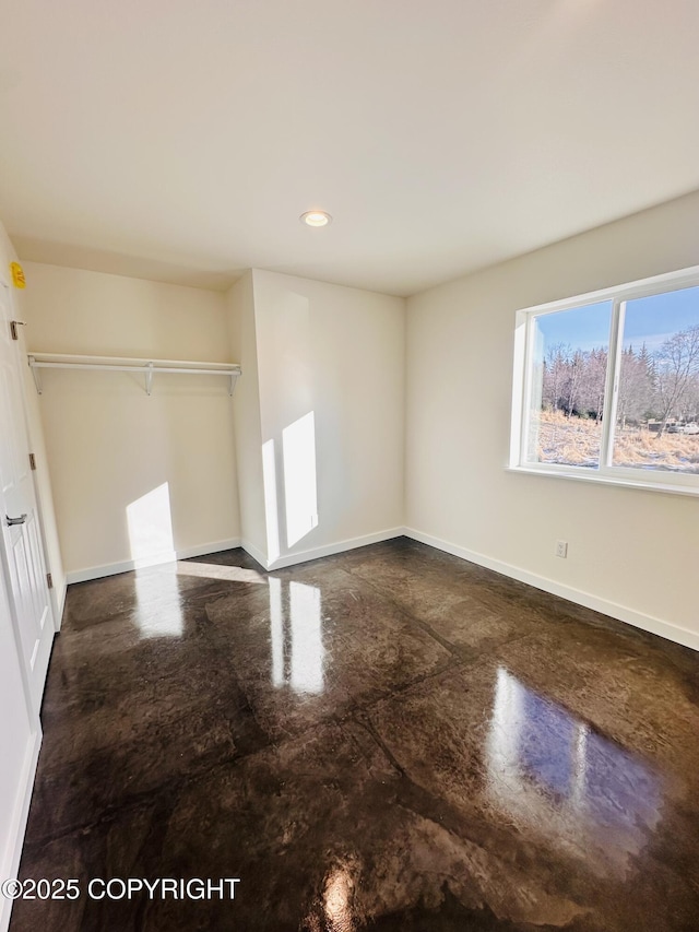 unfurnished bedroom with recessed lighting, baseboards, and concrete floors