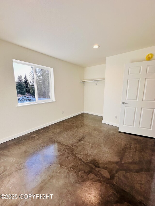 unfurnished room with recessed lighting, baseboards, and concrete floors