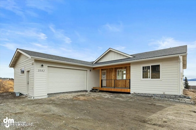 ranch-style house with a porch, an attached garage, board and batten siding, and dirt driveway