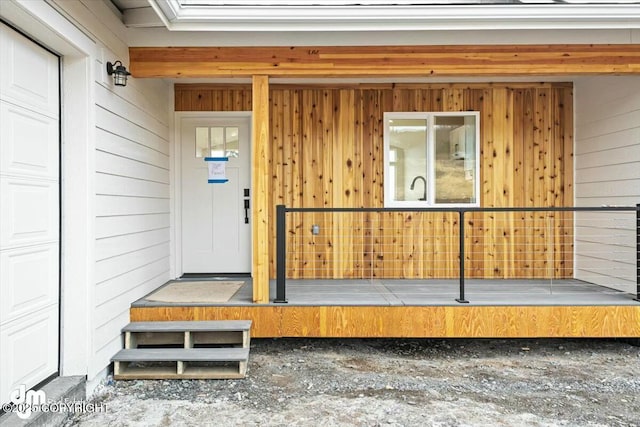 doorway to property featuring a garage and a porch