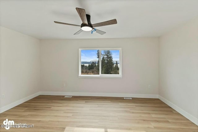 empty room with light wood finished floors, visible vents, ceiling fan, and baseboards