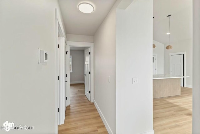 hall with light wood-type flooring and baseboards