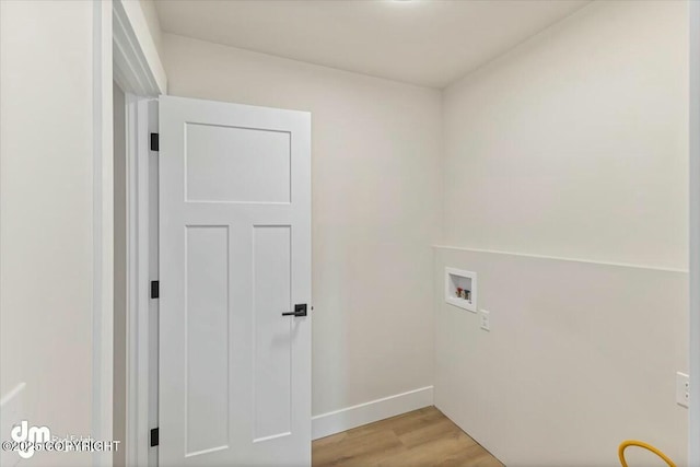 laundry area featuring light wood finished floors, laundry area, hookup for a washing machine, and baseboards