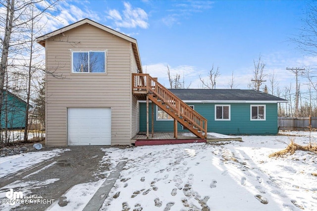 view of front of house with an attached garage, fence, and stairway