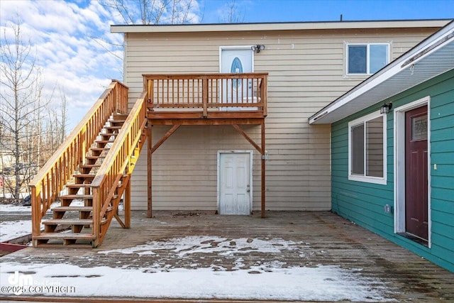 snow covered property with a wooden deck and stairs