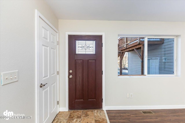 entrance foyer with visible vents, baseboards, and wood finished floors