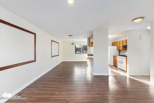 unfurnished room with dark wood-style flooring and baseboards