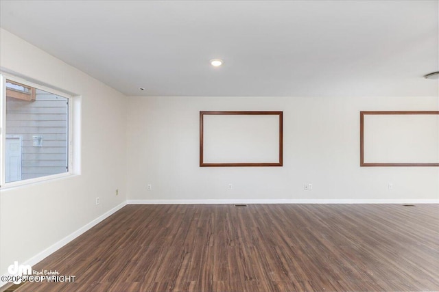 empty room with baseboards, dark wood-type flooring, and recessed lighting