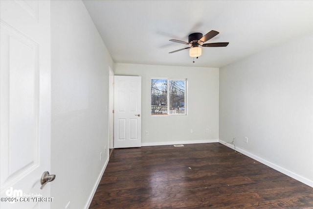 unfurnished room with a ceiling fan, baseboards, and dark wood-style flooring