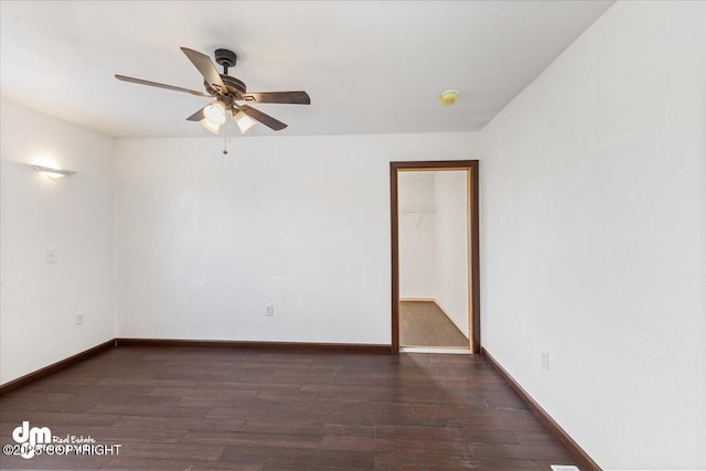 spare room featuring a ceiling fan, dark wood finished floors, and baseboards