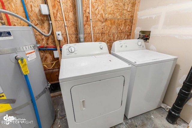 laundry area with laundry area, strapped water heater, and washing machine and clothes dryer