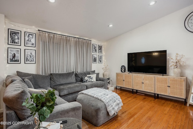 living room featuring recessed lighting, wood finished floors, and vaulted ceiling