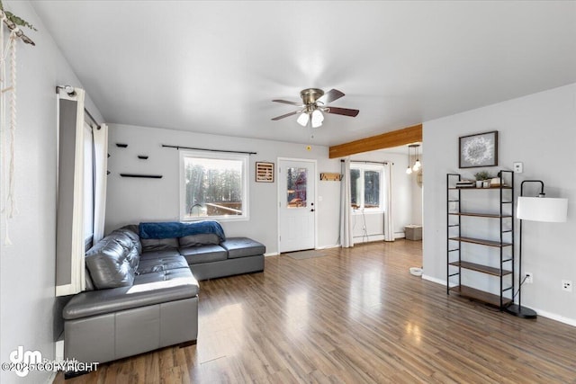 living room featuring baseboards, ceiling fan, and wood finished floors