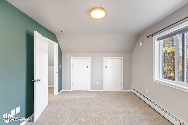 unfurnished bedroom featuring baseboards, lofted ceiling, carpet, and a baseboard radiator