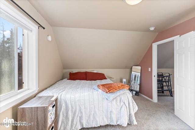 bedroom featuring light carpet, multiple windows, baseboards, and lofted ceiling