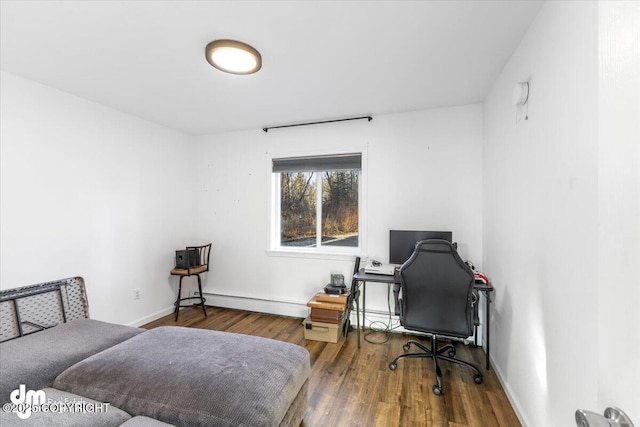 bedroom with wood finished floors, baseboards, and baseboard heating