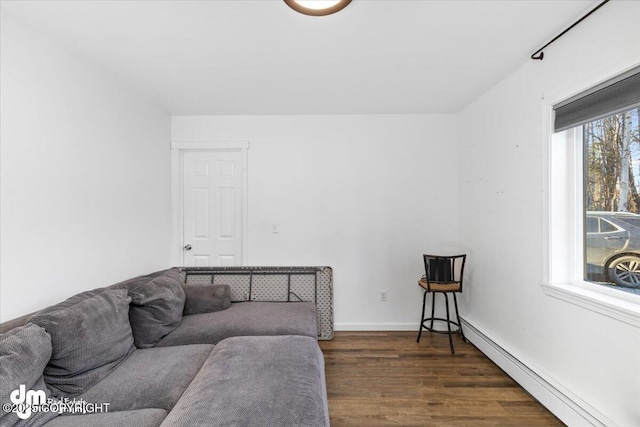 living area featuring baseboards, dark wood-style flooring, and a baseboard radiator