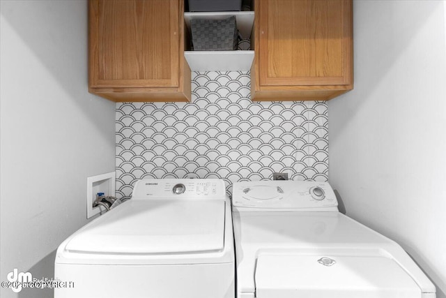 clothes washing area with cabinet space and independent washer and dryer