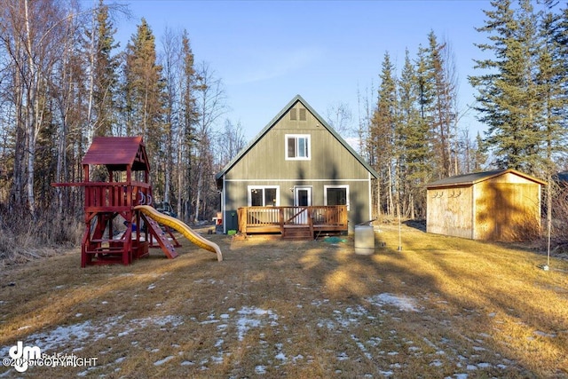 exterior space with a wooden deck, an outdoor structure, a shed, and a playground