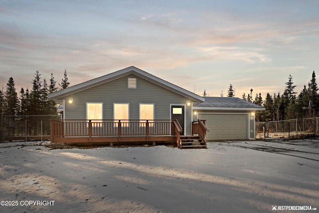 view of front of home featuring a deck, an attached garage, and fence