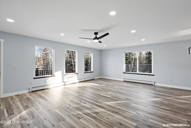 interior space with plenty of natural light, wood finished floors, and a baseboard radiator