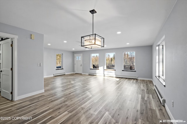 unfurnished living room featuring a baseboard heating unit, wood finished floors, recessed lighting, baseboards, and baseboard heating